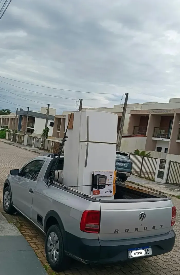 Geladeira e forno elétrico amarrados na caçamba do utilitário